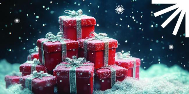 Red presents with silver bows in a pile of snow with a blue background.