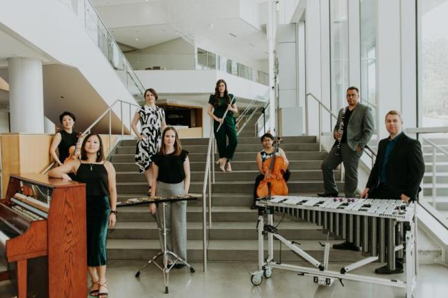 The Khemia Ensemble standing in staggered positions on stairs with their respective instruments