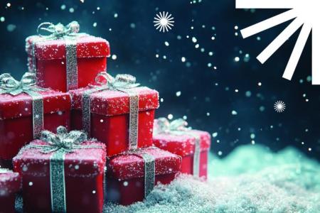 Red presents with silver bows in a pile of snow with a blue background.