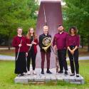 The Southern Wind Quintet standing in a semi-circle in front of a sculpture